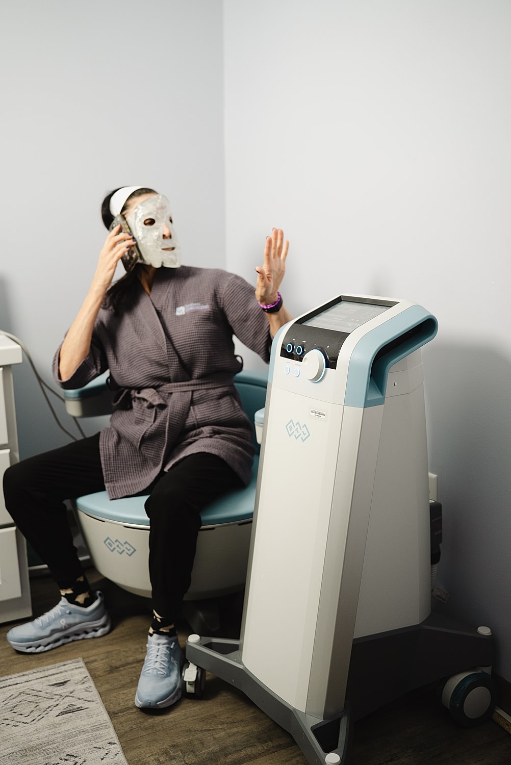 Person on phone wearing facial mask in treatment room