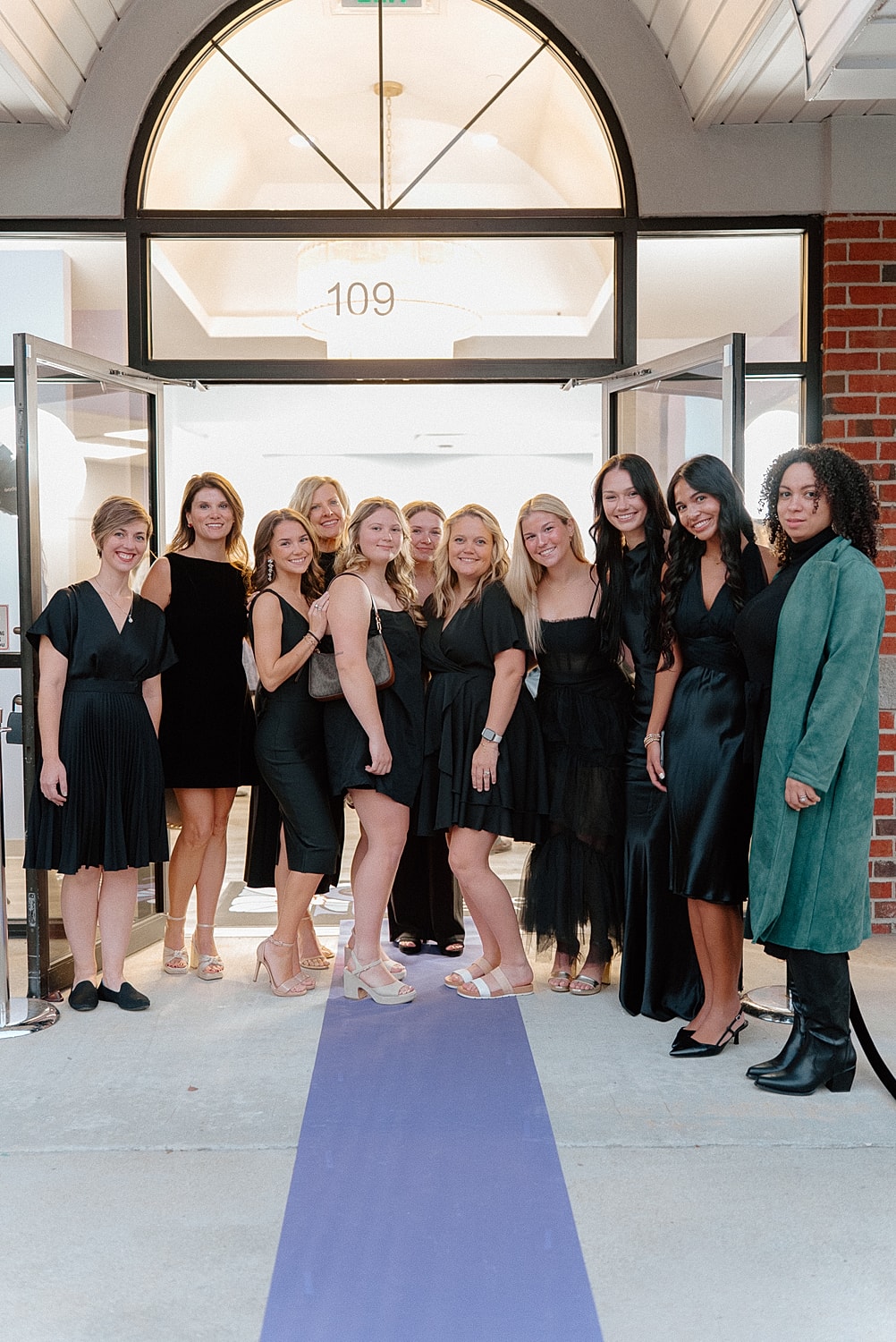 Group of women posing in elegant black dresses.