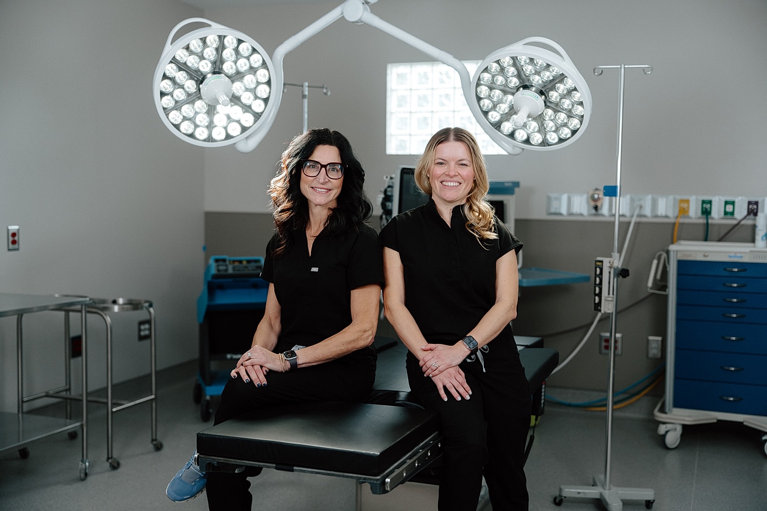 Two women in front of Surgical Associates sign.