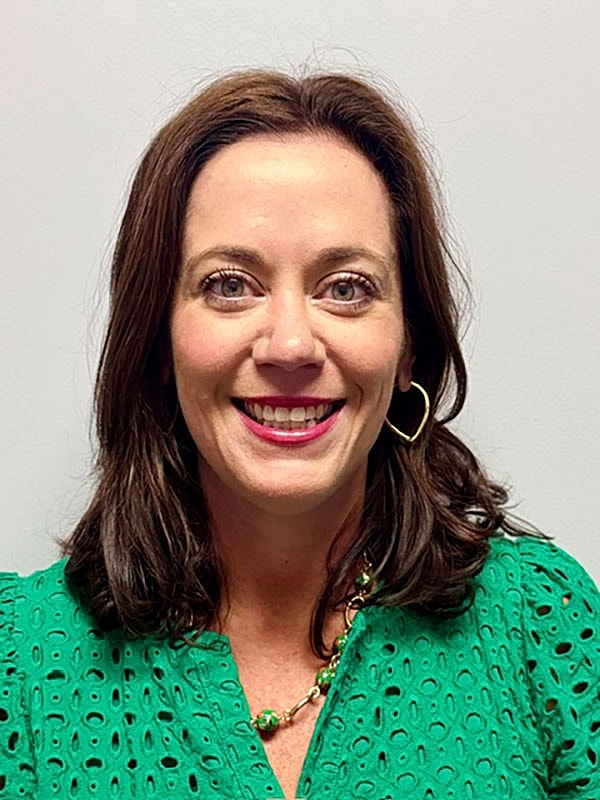 Woman with brown hair and floral blouse.